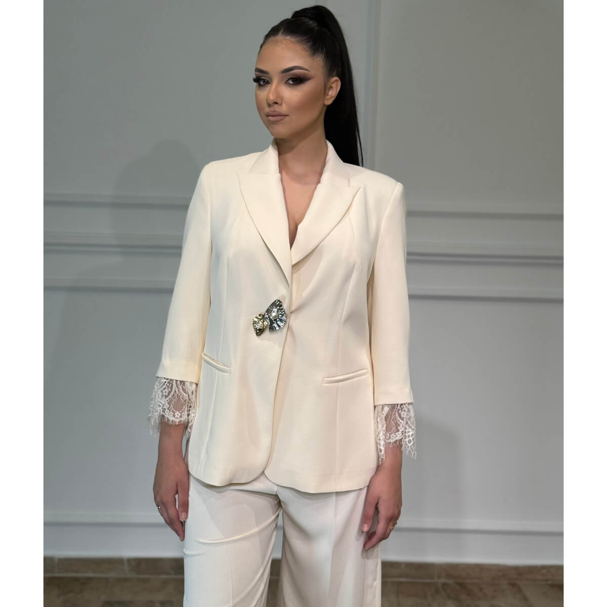 Elegantno žensko odelo Bianca sa čipkom na rukavima i brošem
