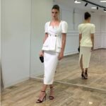 Bela midi strukirana haljina sa peplum detaljem i zlatnim dugmadima