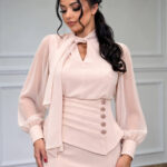 Elegantna puder-roze haljina s mašnom i naglašenim strukom